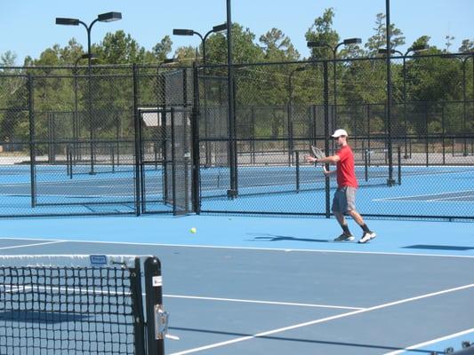 Brett Womack, coaching pro at The Club, hitting on the new blue tennis courts.