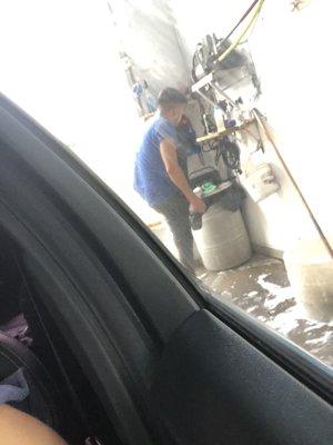 The employee cleaning his shoes instead of the roof or the back of the car.