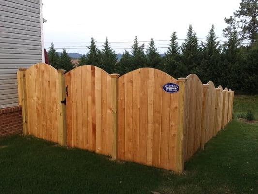 Scalloped cedar privacy fence with pine posts installed by River City Fence