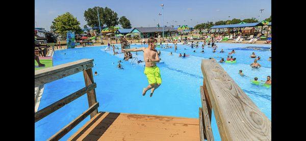 Over view of the activity pool. It has slides, diving boards, rock climbing, zip lining, basketball all into the pool.