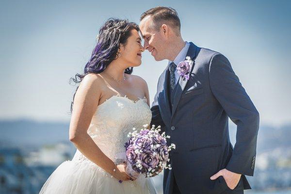 On their wedding day, a couple smiles at each other. They look so happy together. Photographer near me wedding.