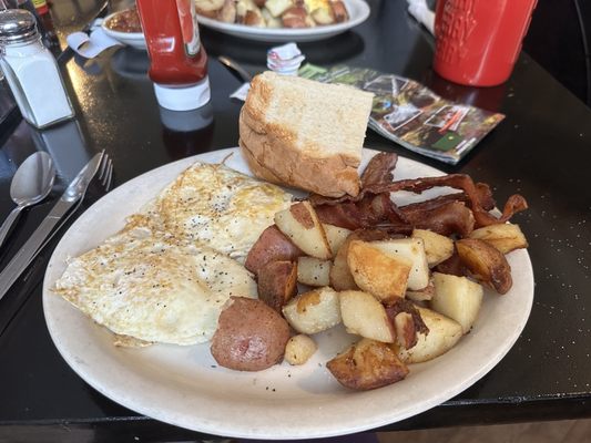 Classic eggs, bacon and home fries with sour dough toast