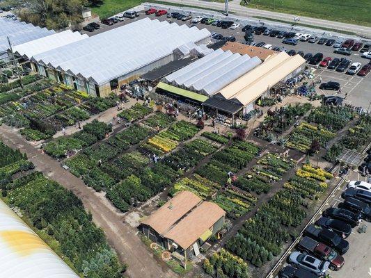 Enjoy ample parking and acres of plants tended by our team of experts. Tan top building in the upper right of the photo is the garden center