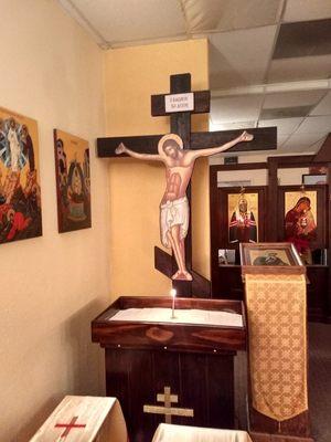 Cross of Christ in foreground, icon screen in background.