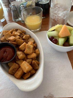 Fresh fruit bowl and hash browns