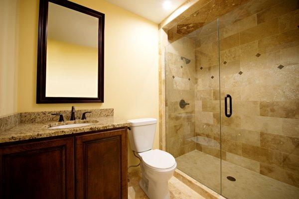 Master Bathroom transformation: linen closet was removed for a large walk in shower. Medallion tiles accent the travertine tile on the wall.