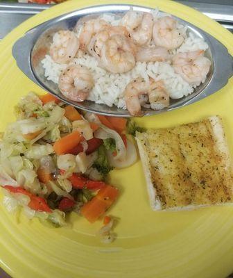 Shrimp over rice with mixed veggies and garlic bread