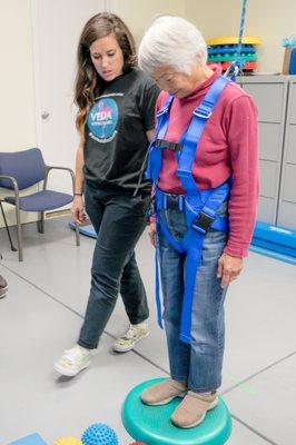 One of our therapists working with a patient on balance exercises with the Safety Overhead harness