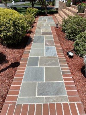 New slate walkway framed by brick pavers