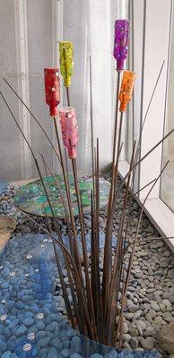 Glass and metal art piece of a reed.