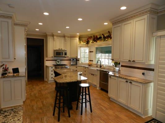 Nicely designed bright, open & airy fluid space with mayonnaise glazed cabinetry, black accent island & granite tops.