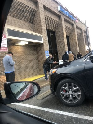 People waiting in the cold rain to be seen.