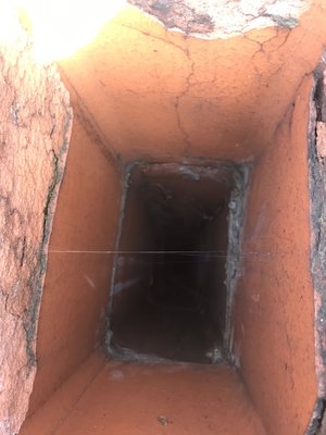 Looking down a deteriorated flue with no raincap