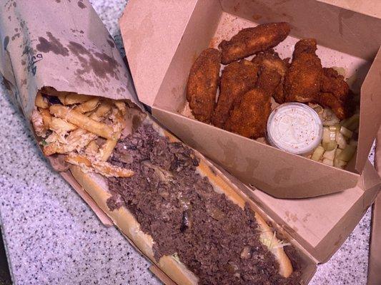 Steak and cheese sub, truffle fries, and old bay wings pictured.