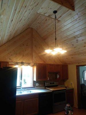 TnG pine boards ,light fixtures to bring more light onto the area of table with reflection of natrual light against the lacquered boards.