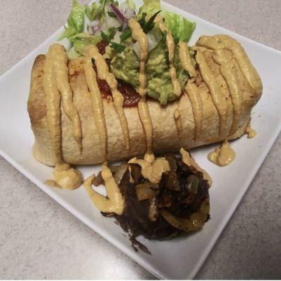 Vegan chimichanga topped with walnut cheese, guacamole, lettuce served w/ refried beans & sautéed onion.