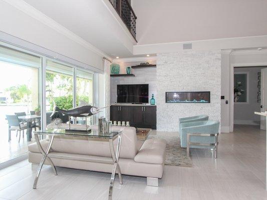 Custom designed built in fireplace and entertainment center with stacked stone accent wall and floating shelves