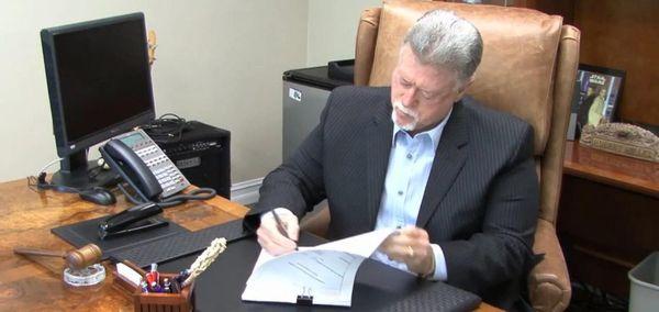 Bob Miller signing bail bonds documentation for client at Orange County Bail Bonds.