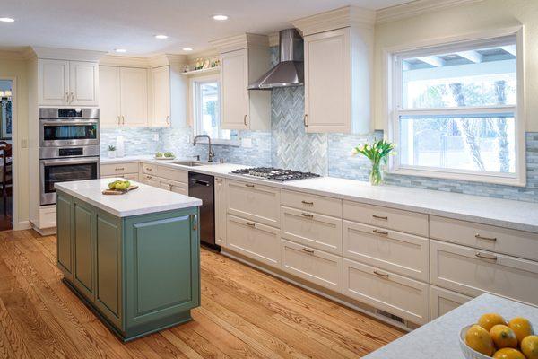 Beautiful  green island, mosaic glass backsplash, white painted cabinets.