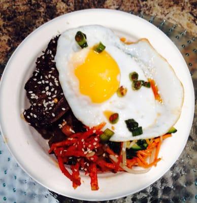 Sesame Grilled Flanked Style Ribs with Brown Rice, Kale, Carrots, Bean Sprouts topped with Fried Egg