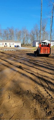 Grading land for proper drainage and to preparing to install a millings driveway.