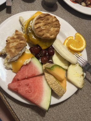 Breakfast biscuit sandwiches and fresh fruit.