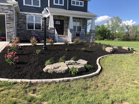 Built barrier around mulch, installed mulch and added plants and rocks.