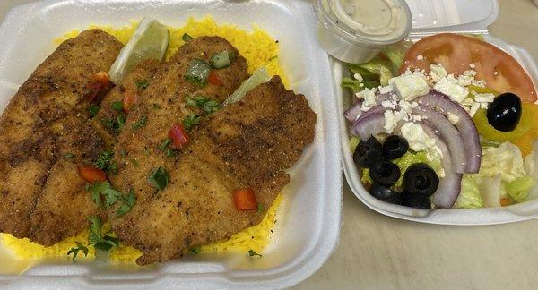 Chef  touch fried fish with Greek rice and Greek salad