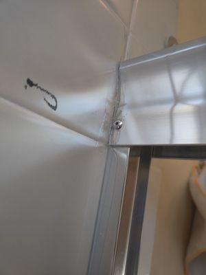 Ribbet added to hold top rail in place shower door