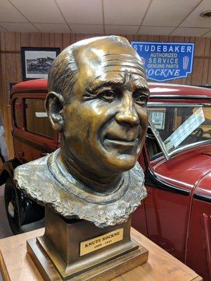 Coach Knute Rockne bust with the Studebaker Rockne in the back ground.