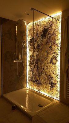 Walk-in shower renovation with lighted transparent onyx