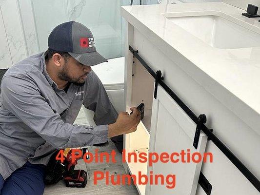 Home inspector inspecting the plumbing system as part of a 4 point inspection.