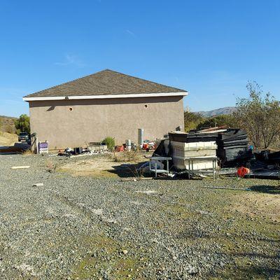 Trash at back of garage at vacant house cleanup