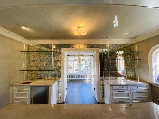 Antique mirror cut into tiles installed around entry with 1/2" clear shelves supported by satin brass rods.