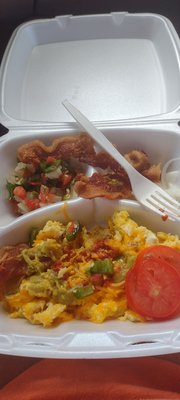 Yummy breakfast platter-Eggs scrambled with ham and cheese, bacon slices, and sliced tomato with fresh pico de Gallo.