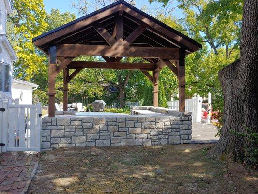 Backside of small outdoor kitchen, complete with stainless steel appliances.