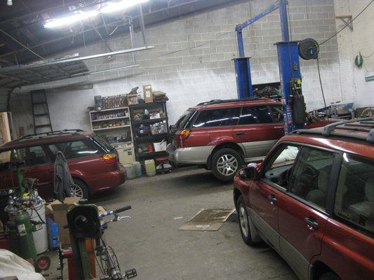 Three red Subarus in the shop