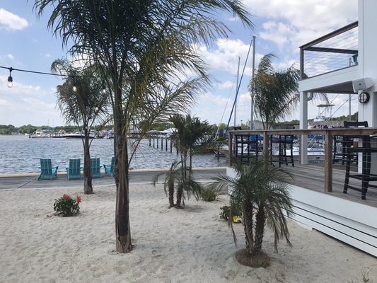 Photo of side deck seating area on right and some of beach area on left.