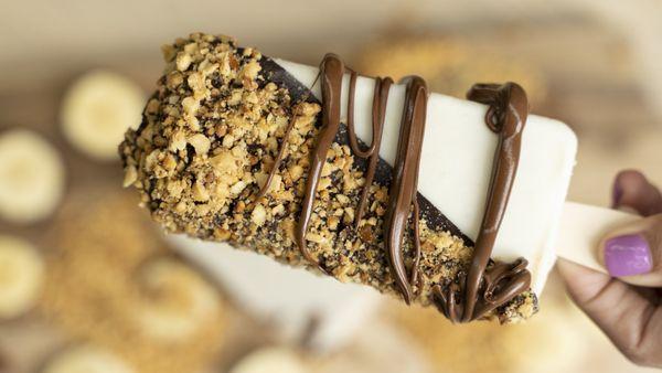 Banana filled with Nutella Paleta dipped in Dark Chocolate, topped with Peanuts, & drizzled with Nutella