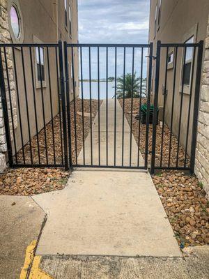 Conroe TX Fence contractors near Lake Conroe, TX installed a wrought iron gate entrance between properties for security.