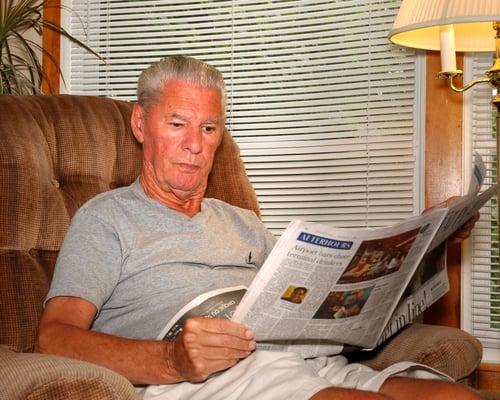 Senior Home Sharing Resident - Paul reading the morning newspaper