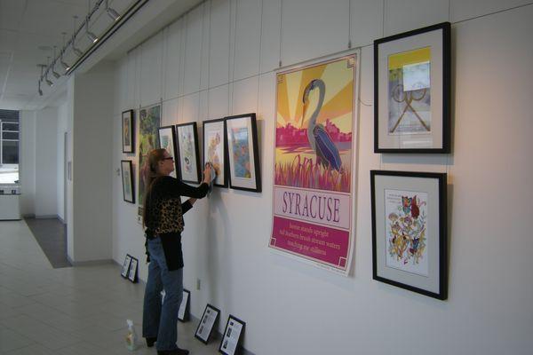 Cheryl Chappell installing a traveling exhibit for the Syracuse Poster Project at Upstate Cancer Center, February, 2017.