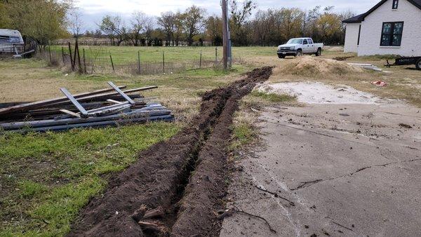 ditch is dug ready to install pipe for tree lights .