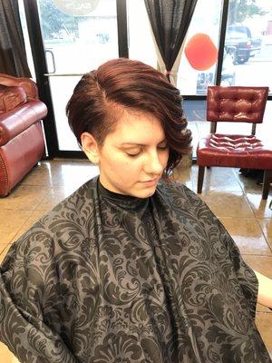 asymmetrical bob with red highlights on dark brown base