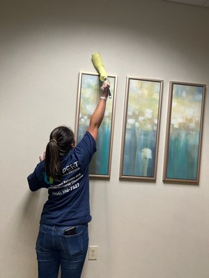 Dusting high areas of facility (art frames)