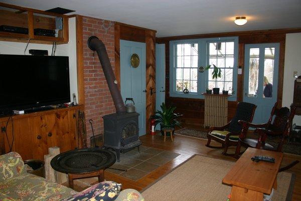 Living room with cozy couches, cable and streaming services, and wood burning stove