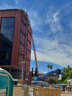 ASU project installing netting behind the screen walls to prevent pigeons and doves nesting on the back beans using 85' and 125' boom lifts.