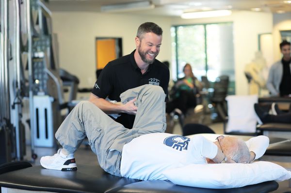 Clinic Director and Physical Therapist Jordan Brocker treating patient's leg.