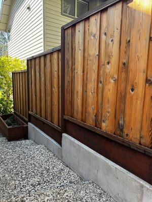 Fence on top of concrete retaining wall to make it stronger