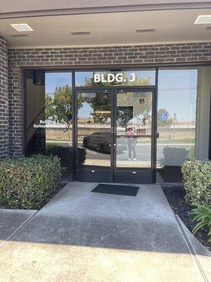 There are two doors that say BLDG J. This one is close to their lobby.